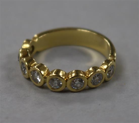 An 18ct gold and eight stone collet set diamond half hoop ring, size M.